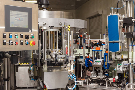 自动瓶盖机的作用机理.工厂为酒精饮料的生产照片