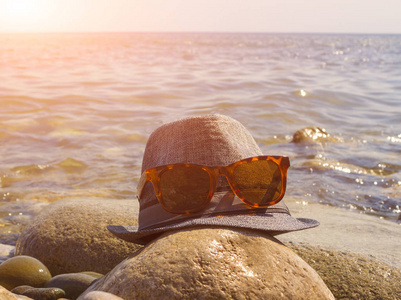 帽子和太阳镜休息躺在海边上亮起的太阳