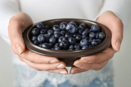 女人抱着碗新鲜 acai 浆果，特写