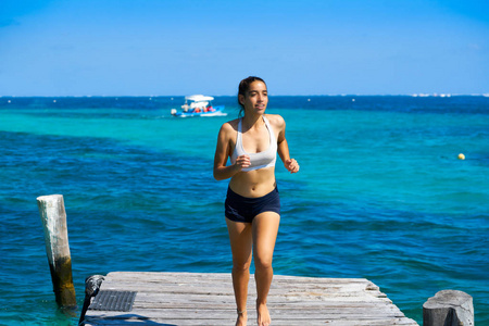 拉丁女孩奔跑在加勒比海码头海滩玛雅利维拉