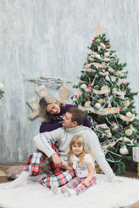 快乐圣诞快乐 假期家庭交换礼物。父和女儿开心和附近室内圣诞树一起玩耍