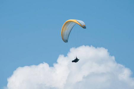 滑翔伞飞行在蔚蓝的天空背景下的云