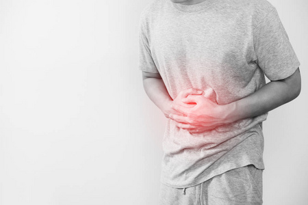 一个男人手捂腹部,红色突出显示的肚子痛的概念和其他胃病,与副本空间