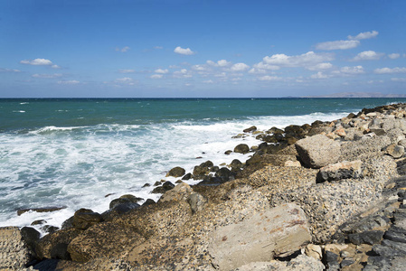 海浪在多石的海滩上，形成一朵浪花。波和溅上海滩。岩石上的海浪