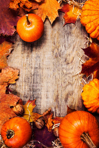 感恩节边界或框架与橙色南瓜和五颜六色的叶子在木制背景。 感恩节，秋日，秋日，秋日
