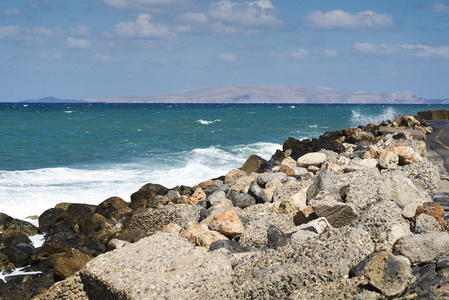 海浪在多石的海滩上，形成一朵浪花。波和溅上海滩。岩石上的海浪