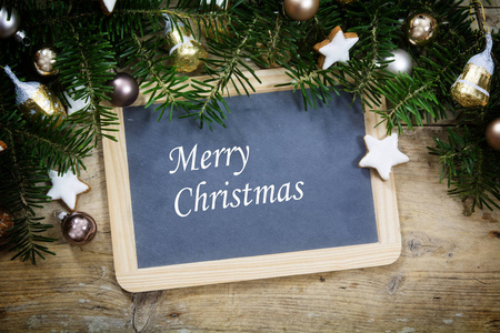 石板书写板与冷杉的树枝，圣诞球和饼干上质朴的木板，样本文本圣诞快乐