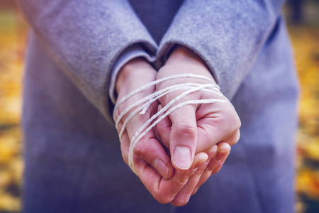 特写的绳子特写的手用绳子捆着的年轻女人.压制和暴力行为的概念照片