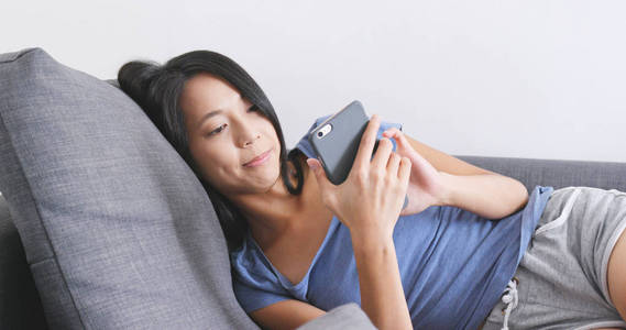 在沙发上使用手机的女人