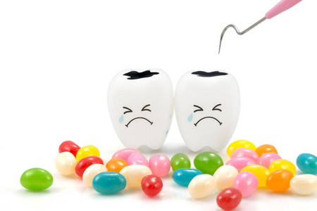 牙齿哭情感与牙菌斑清洁工具和糖果，在白色背景上