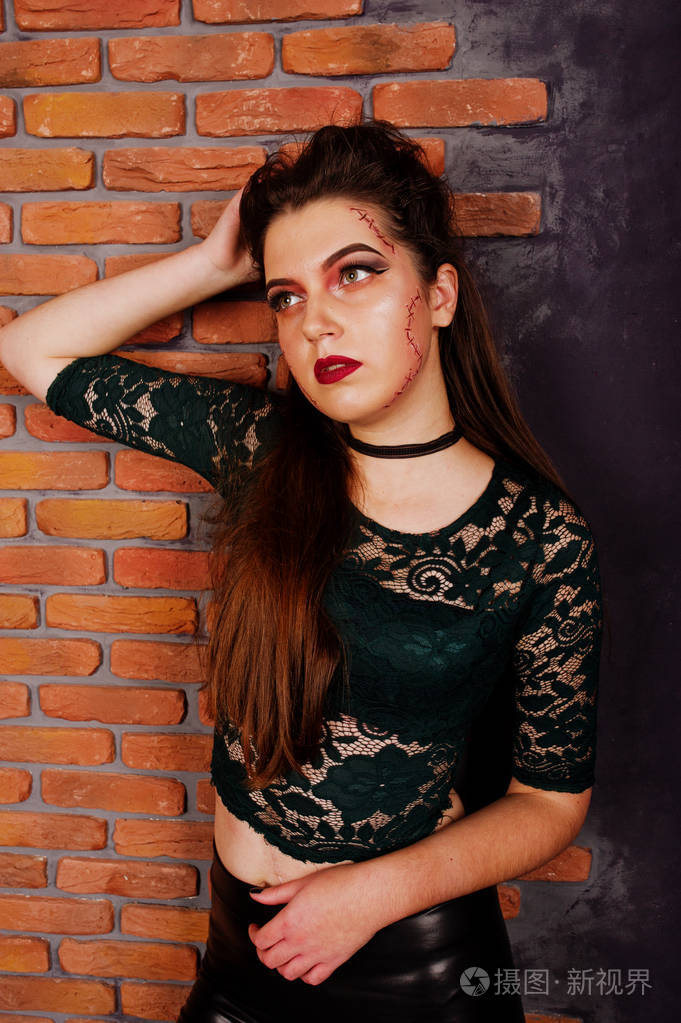 在绿色的衬衫和皮裤搭配明亮化妆的黑人女孩