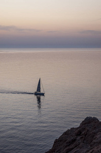 在日落时关闭海岸的 Ile de la 彼特拉 石头岛，岬岛上部科西嘉岛一个著名城市鲁塞 红岛，在地中海航行的一艘帆船