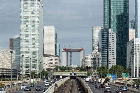 拉德芳斯区现代建筑物及动态街道交通在巴黎业务。在阴天的时候的玻璃幕墙摩天大楼的城市风光。经济 财政 道路网络和城市交通概念