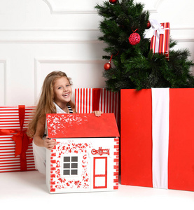 宝贝女孩孩子玩圣诞红房子在游戏室在家里或幼儿园的小娃娃玩具