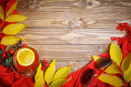桌上，装饰着秋天的落叶 浆果和新鲜的茶。秋天。秋天的背景