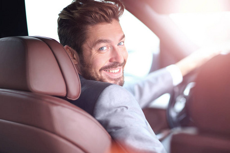 英俊男人微笑着商业驾驶他的车的肖像