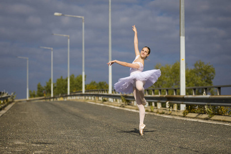在公路上跳舞的年轻芭蕾舞演员