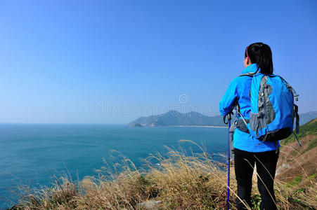 徒步女子站在海边的岩石上