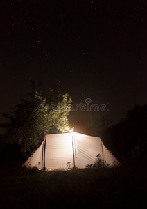 夜宿帐篷在黑暗的星空背景下。大熊座