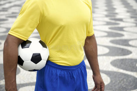 巴西足球运动员身穿制服，手里拿着足球