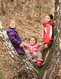 三个孩子女孩倚在树上