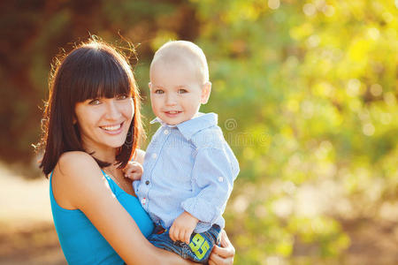 美丽幸福微笑的母亲与婴儿户外肖像