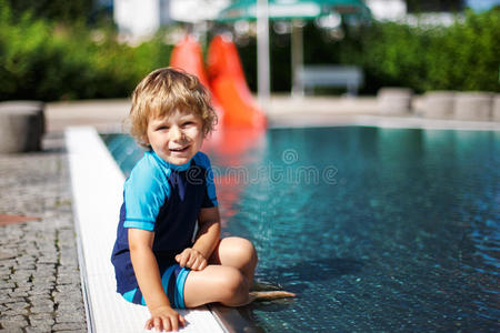 可爱的幼儿在室外游泳池边玩水