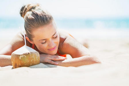 悠闲的年轻女子躺在椰子海滩上