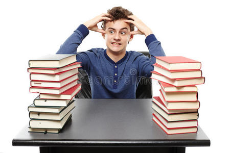愤怒的学生坐在书桌旁，双手放在两堆书中间