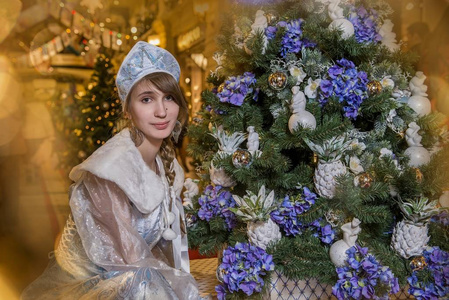 女孩在雪少女服装和一棵圣诞树