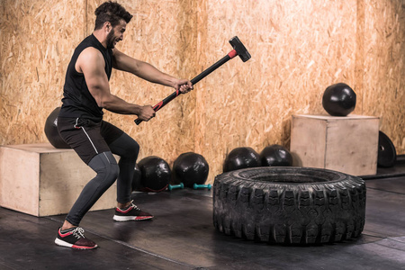 体育健身男子击中车轮轮胎与锤子雪橇 Crossfit 训练, 年轻健康的家伙