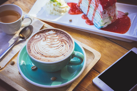 张木桌和蛋糕摩卡咖啡 lattee 杯放松时间上咖啡馆