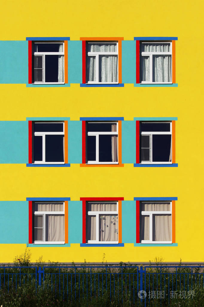 漂亮的五颜六色的房子儿童幼儿园.九窗口, 蓝色, 黄色和米色颜色