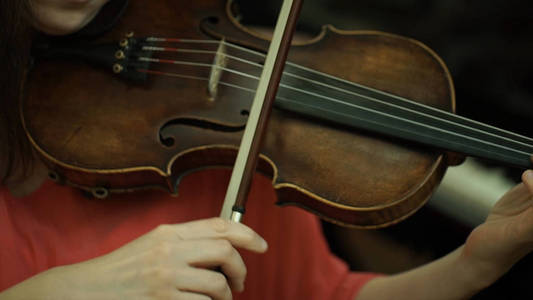 女孩把小提琴的琴弦。女孩的手，指板小提琴