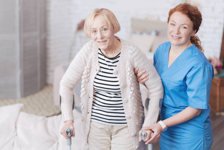 细心的女医生帮助她年迈的病人走路
