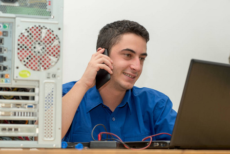 年轻男人在坏掉的计算机上工作的技术人员和调用 cus