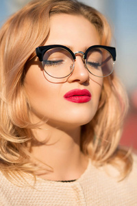 时尚的魅力金发模特肖像戴着清晰的眼镜