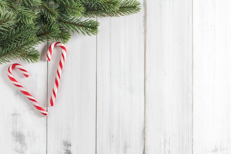 圣诞冷杉树枝上的糖果在白色的质朴的宇
