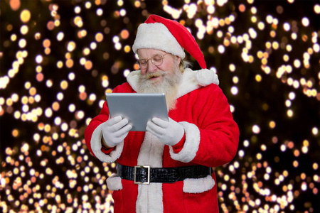圣诞老人在计算机平板电脑上阅读