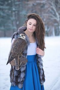 美丽的女人和猎鹰在冬天
