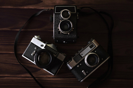 三旧老式相机在木桌上