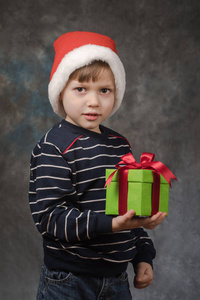 男孩在圣诞老人帽子与礼物