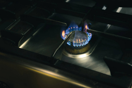 一个人用自动点火的方式点燃煤气炉.