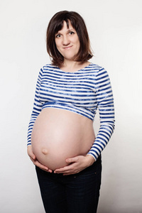 愉快的怀孕的妇女在灰色背景