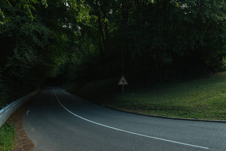 在法国诺曼底地区的绿色森林中, 一条空的沥青弯曲的道路。夏季自然乡村景观交通与路网理念
