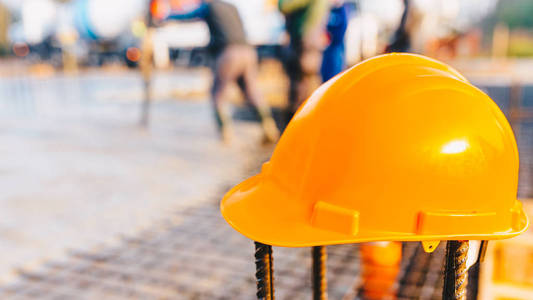 背景模糊的建筑工地橙色安全帽照片