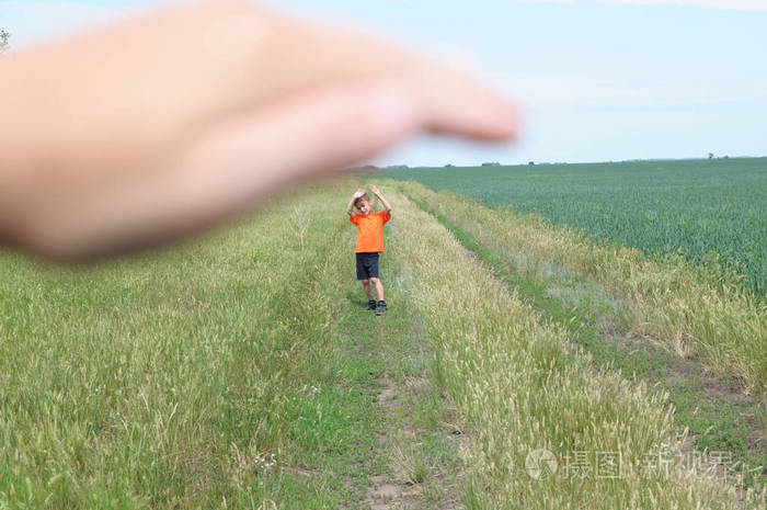 大手庇护小男孩在田野里