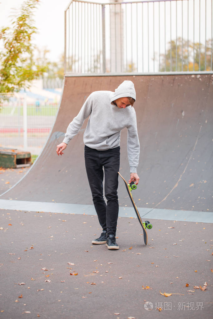 年轻的滑冰男孩在户外滑冰公园玩把戏.体育概念