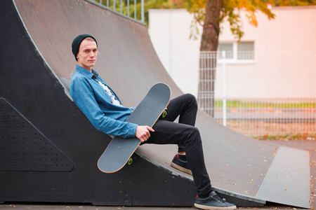 年轻的 skatebarder 摆在滑板的滑板。体育概念