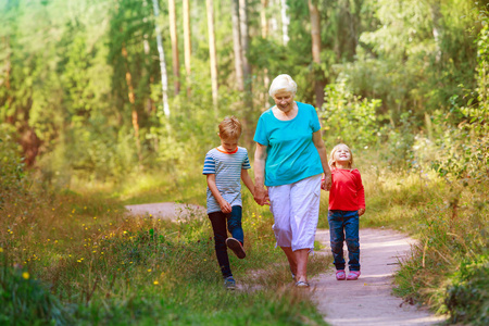 愉快的资深祖母与孩子漫步在自然